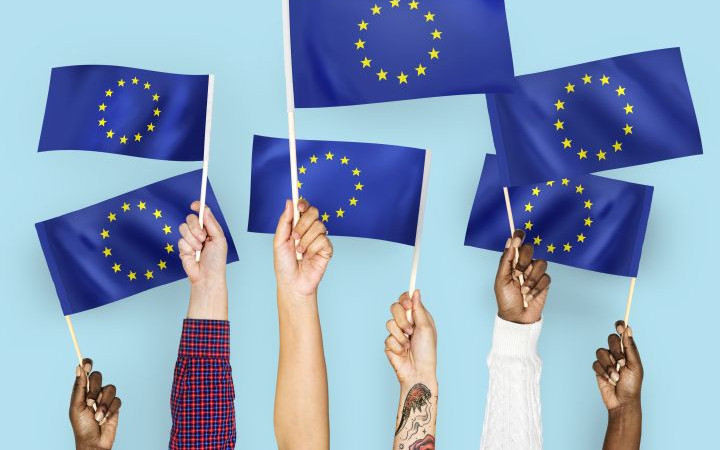 Hände, die die europäische Fahen hochhalten.