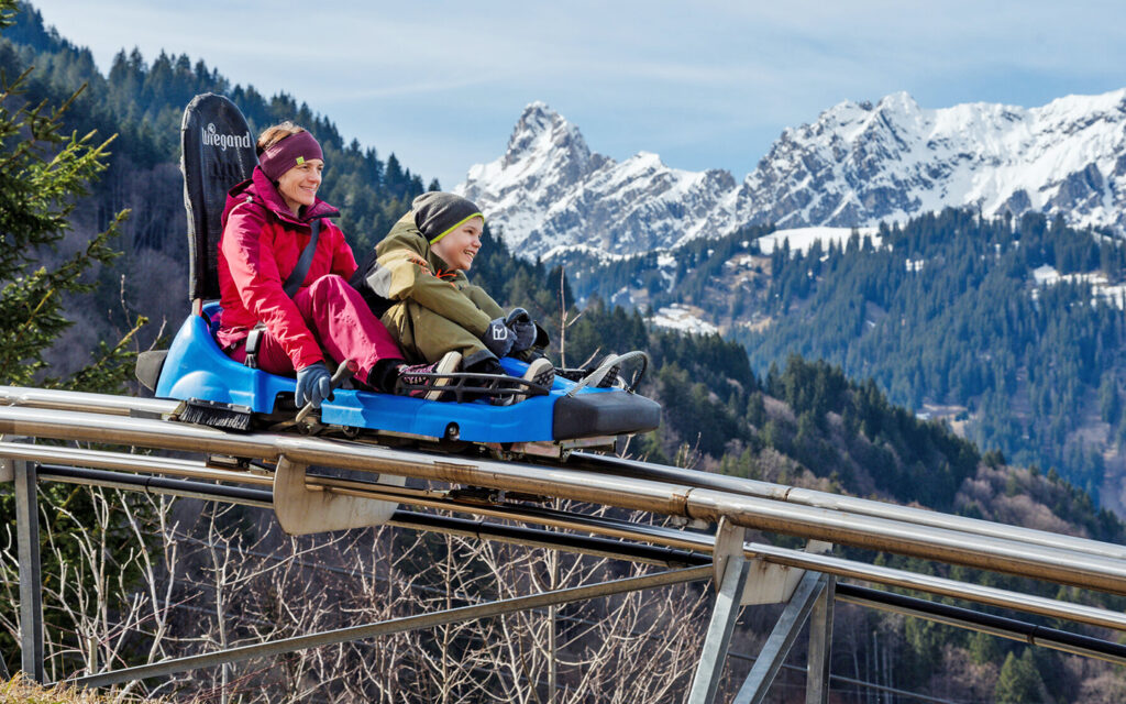 Mutter und Sohn fahren mit dem Alpine Coaster am Golm
