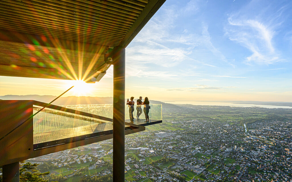 Leute stehen auf der Plattform bei der Karren Seilbahn im Sonnenuntergang