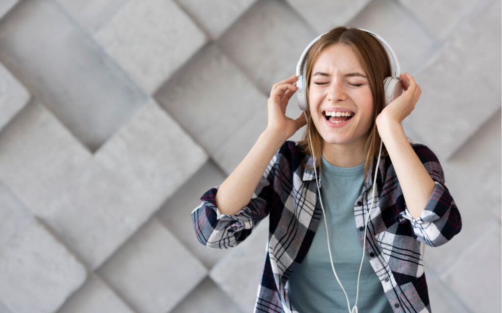 Eine Jugendliche mit Kopfh&ouml;rern freut sich &uuml;ber die Musik.
