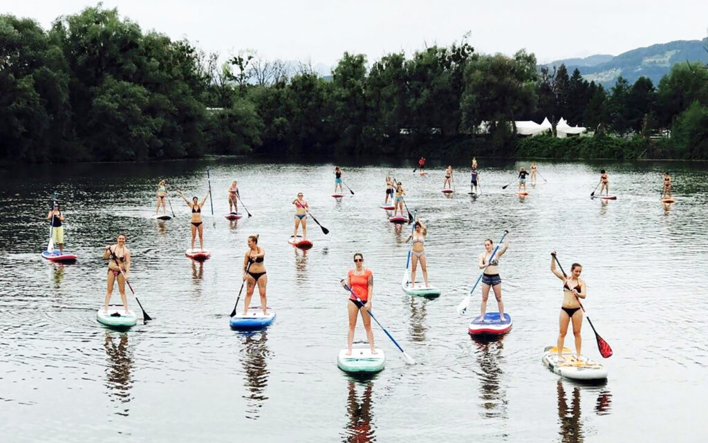 Leute stehen auf einem Stand up paddle und paddeln im Bodensee