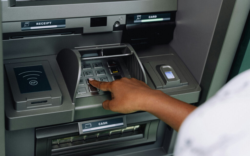 Eine Frau hebt Geld an einem Bankomaten ab.