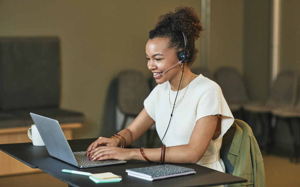 Junge Frau macht am Computer einem Phonecall