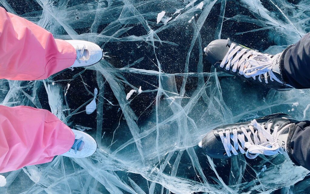 Man sieht die Eislaufschuhe von einem Mädchen und einem Jungen - Kamera von oben herab