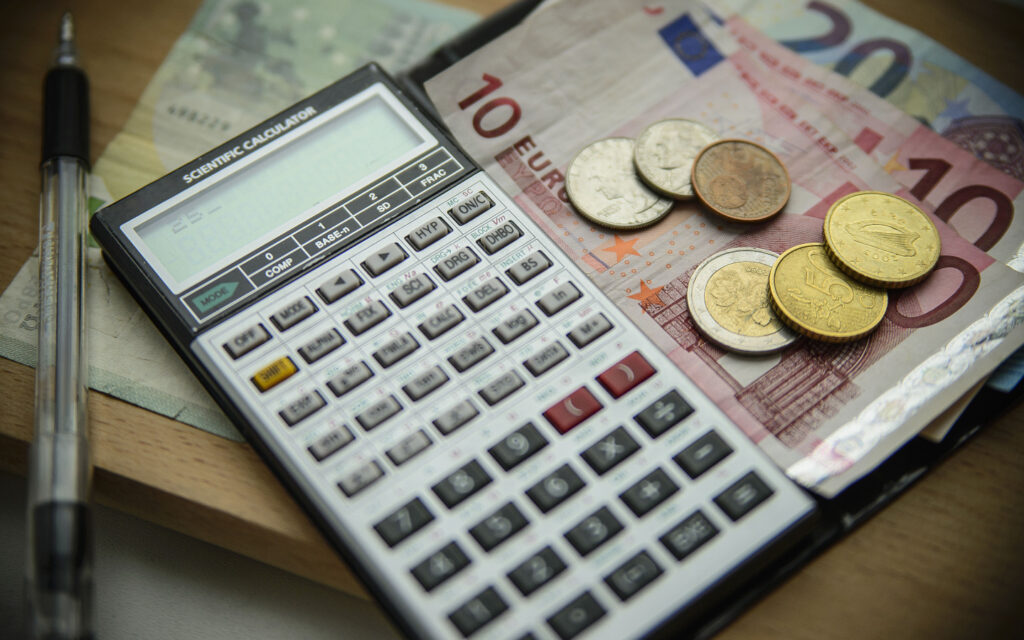 Taschenrechner mit Euroscheinen und M&uuml;nzen daneben.