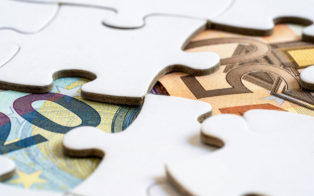 Geldscheine werden wie Puzzlest&uuml;cke zusammen gepuzzlet