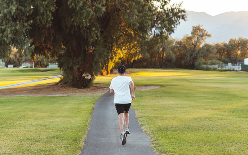 Ein Mann joggt durch einen Park.